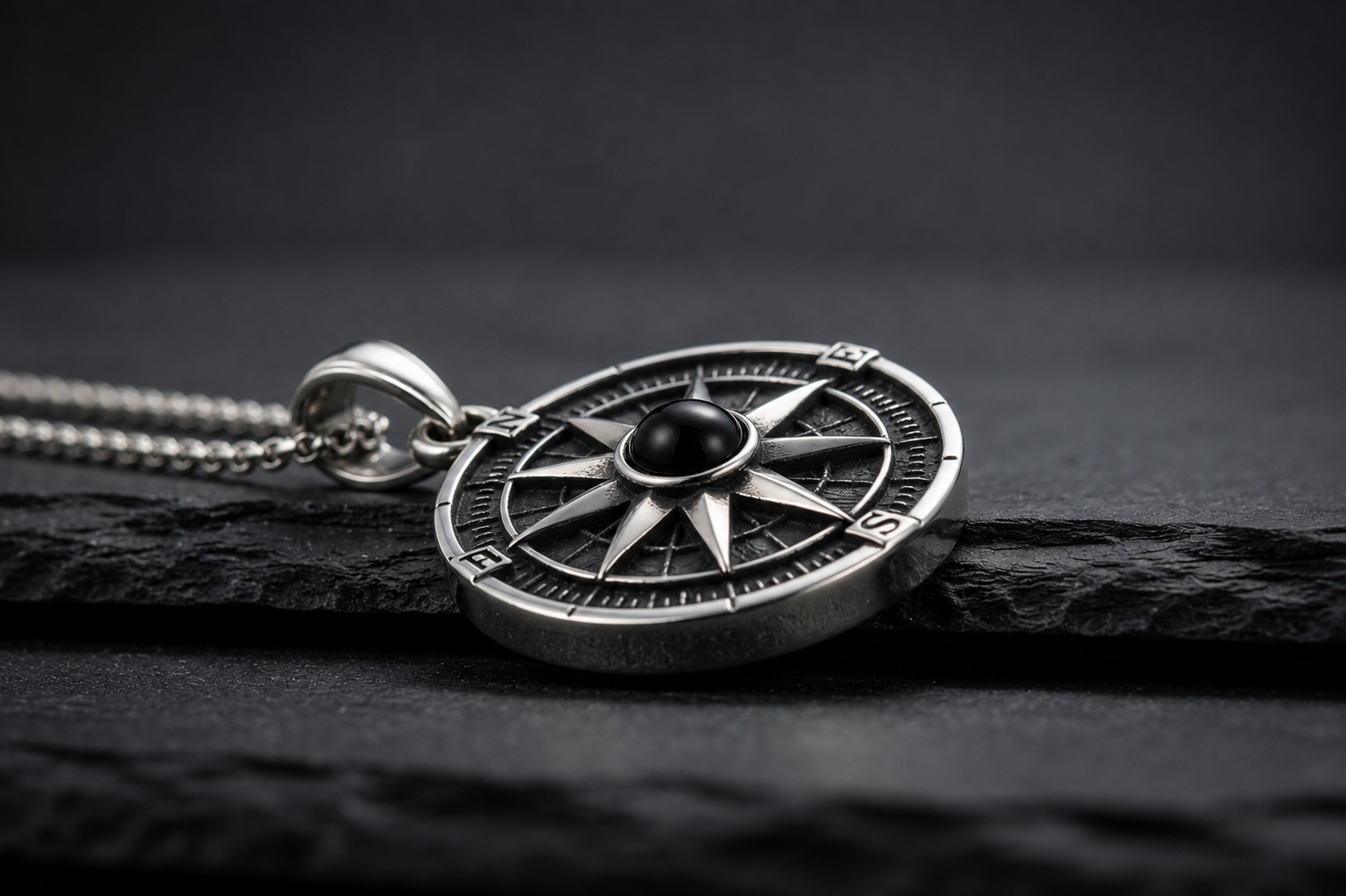 Close-up of the Praise Jewels Compass Pendant showing natural black onyx and compass detailing