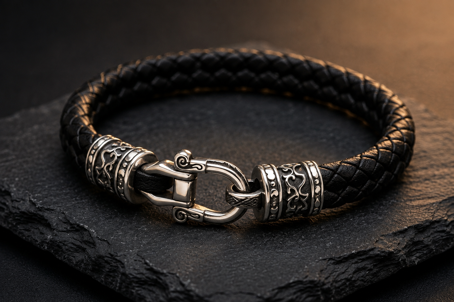 Close-up of braided black leather bracelet with engraved sterling silver hook clasp
