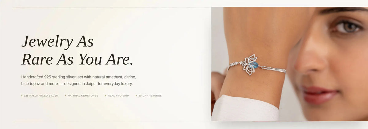 A close-up promotional image showing a woman wearing a delicate silver-toned bracelet with a lotus and a small blue stone accent. The left side includes marketing text reading 'Jewelry As Rare As You Are.